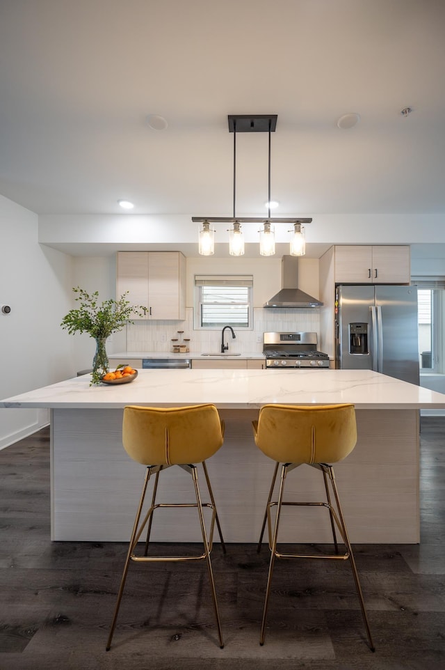 kitchen with tasteful backsplash, a kitchen island, stainless steel appliances, and wall chimney exhaust hood