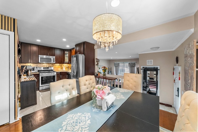 dining area with visible vents, ornamental molding, light tile patterned floors, recessed lighting, and a notable chandelier