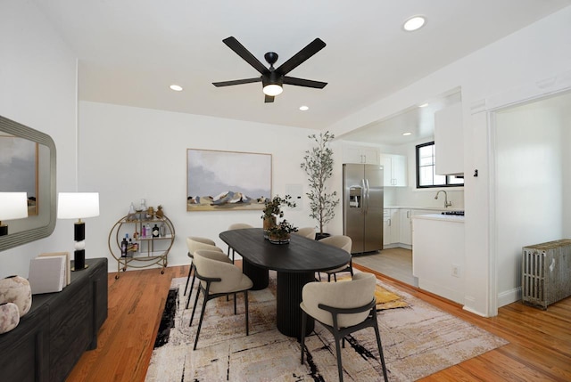 dining area with ceiling fan, sink, and light hardwood / wood-style floors