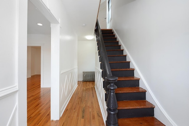 staircase featuring wood-type flooring and radiator