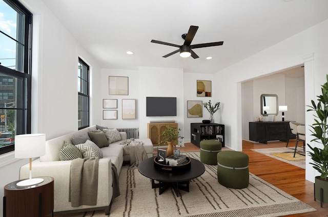 living room featuring wood-type flooring and ceiling fan