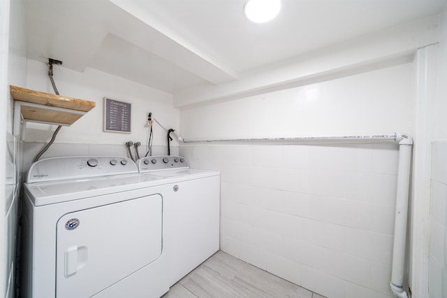 laundry area featuring washer and clothes dryer and light hardwood / wood-style floors