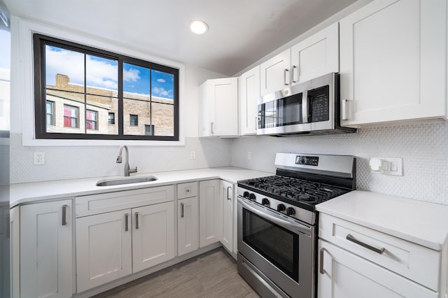 kitchen with white cabinetry, appliances with stainless steel finishes, sink, and decorative backsplash