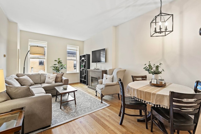 264 9th St Unit 3C, Jersey City, NJ 07302 - living area featuring a chandelier, light wood-style flooring, and a glass covered fireplace