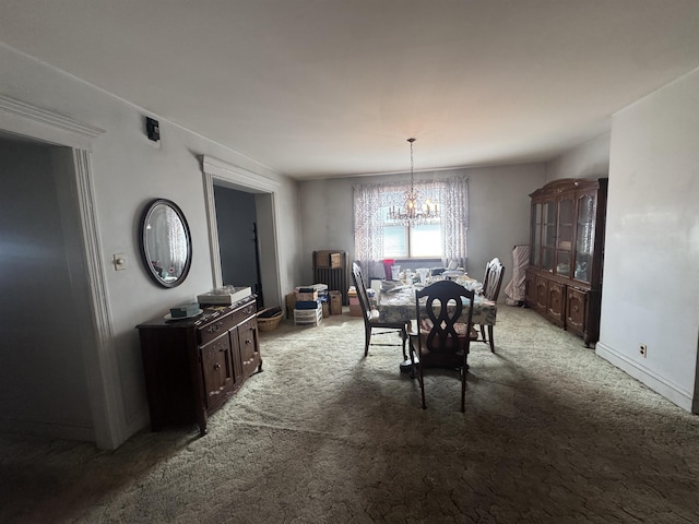 carpeted dining area with a notable chandelier and baseboards