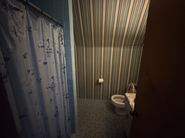 full bath with curtained shower and toilet