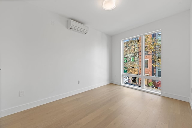 391 1st St Unit 2-C, Jersey City, NJ 07302 - unfurnished room with a wall unit AC, light wood-style floors, and baseboards