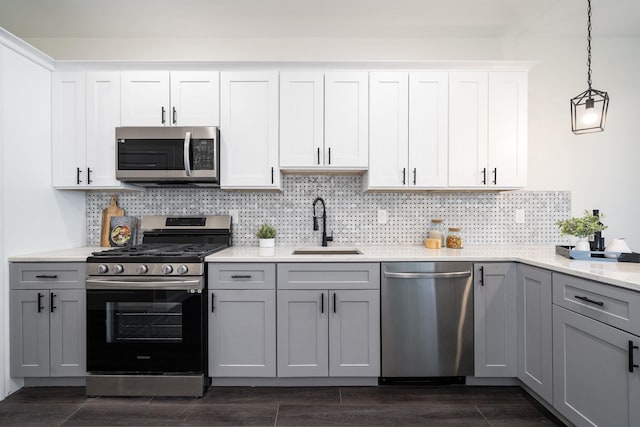 kitchen featuring gray cabinetry, appliances with stainless steel finishes, hanging light fixtures, sink, and white cabinets