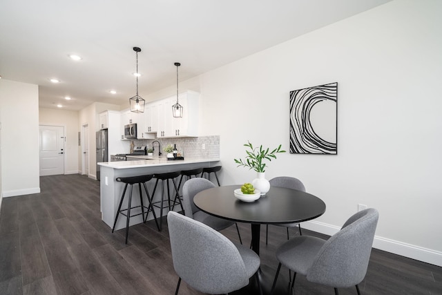 dining space with dark wood-type flooring and sink