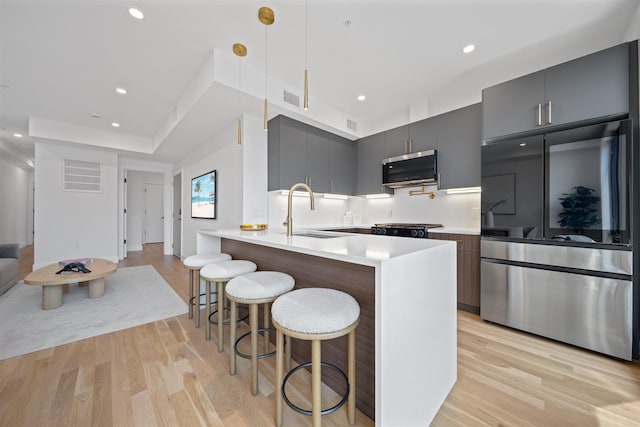 28 Beacon Ave Unit 2, Jersey City, NJ 07306 - kitchen with stainless steel appliances, modern cabinets, light wood-type flooring, a breakfast bar, and recessed lighting
