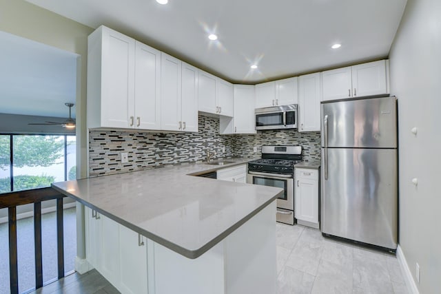 98 Sandpiper Ky, Secaucus, NJ 07094 - kitchen with stainless steel appliances, a peninsula, white cabinetry, tasteful backsplash, and recessed lighting