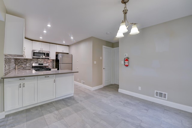 98 Sandpiper Ky, Secaucus, NJ 07094 - kitchen with appliances with stainless steel finishes, tasteful backsplash, a peninsula, white cabinetry, and recessed lighting