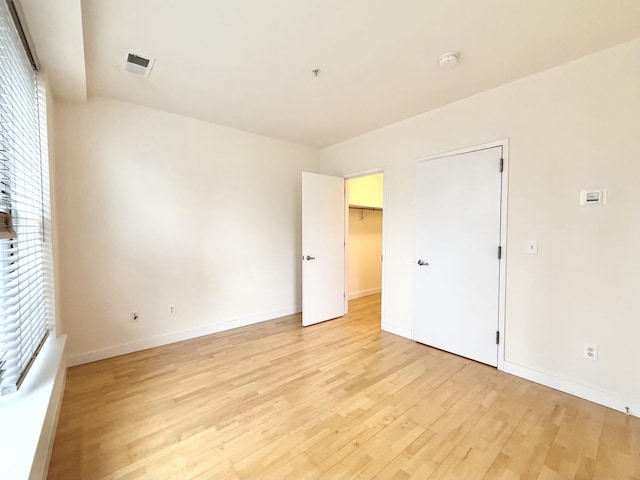 empty room featuring visible vents, baseboards, and light wood-style floors