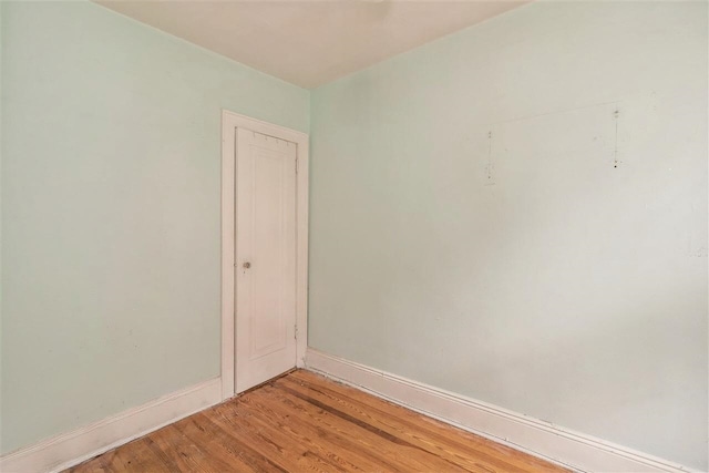 spare room featuring light wood-style floors and baseboards