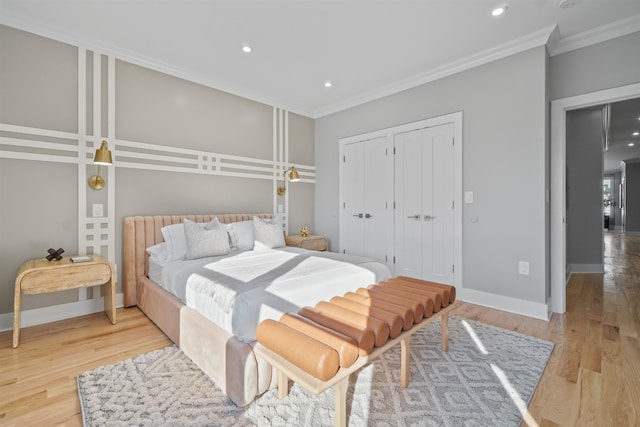 bedroom with light wood-type flooring, crown molding, and a closet