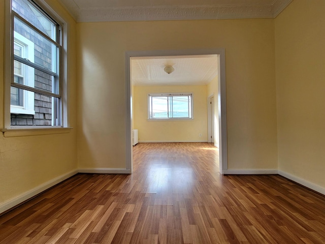 1214 79th St, North Bergen, NJ 07047 - empty room with wood finished floors, crown molding, and radiator heating unit