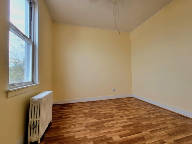 1214 79th St, North Bergen, NJ 07047 - empty room with radiator heating unit, wood finished floors, and ceiling fan