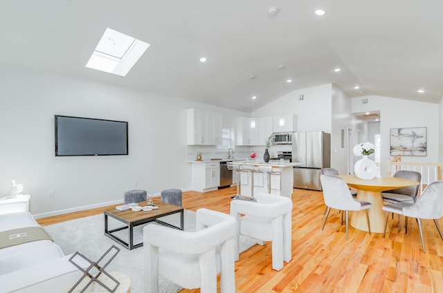 living room featuring recessed lighting, baseboards, high vaulted ceiling, and light wood-style flooring