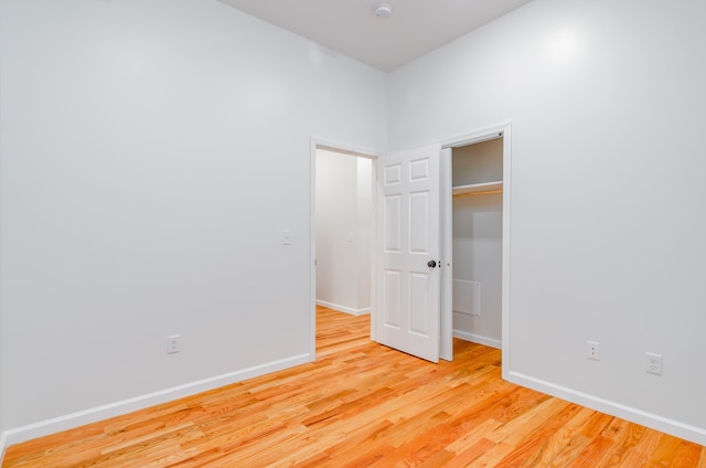 unfurnished bedroom with a closet, light wood-type flooring, and baseboards