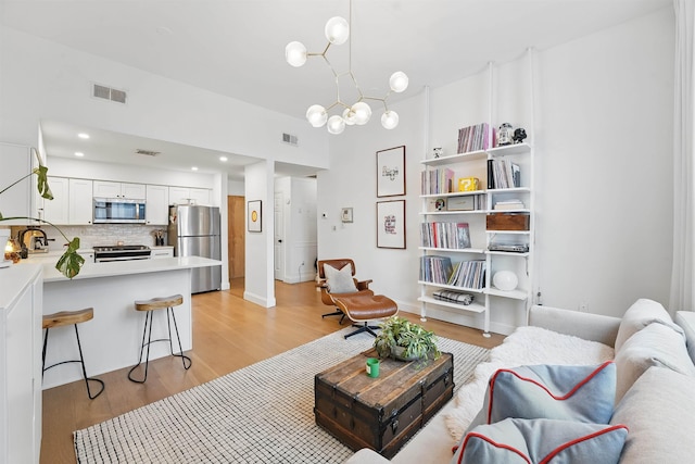 120 Sherman Ave Unit 2B, Jersey City, NJ 07307 - living room with light wood-style floors and a chandelier