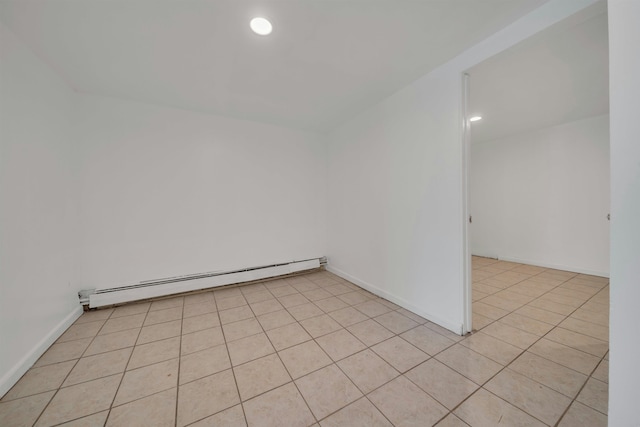 tiled spare room with a baseboard heating unit