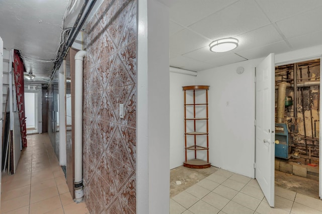 hallway with light tile patterned floors and a drop ceiling