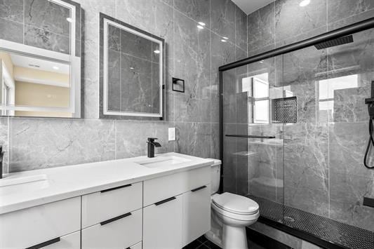 3611 John F Kennedy Blvd Unit 2, Jersey City, NJ 07307 - full bath featuring tile walls, a shower stall, vanity, and toilet