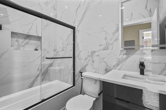 3611 John F Kennedy Blvd Unit 2, Jersey City, NJ 07307 - full bathroom featuring vanity, toilet, combined bath / shower with glass door, and tile walls