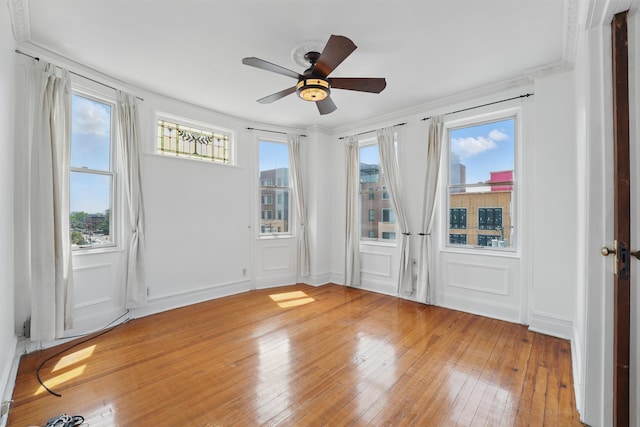 3444 John F Kennedy Blvd Unit 4F, Jersey City, NJ 07307 - spare room featuring light wood-style flooring, a ceiling fan, plenty of natural light, a decorative wall, and crown molding