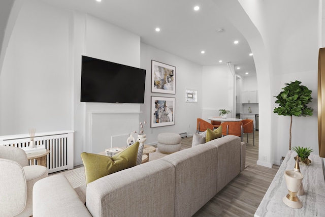 living room with light hardwood / wood-style floors, a baseboard radiator, and radiator heating unit