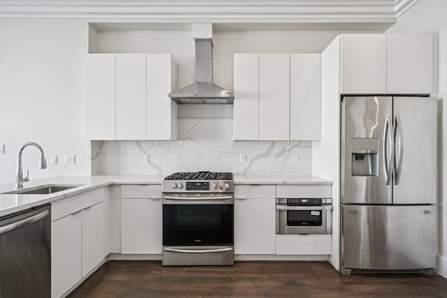 kitchen featuring a sink, dark wood-style floors, stainless steel appliances, wall chimney range hood, and decorative backsplash
