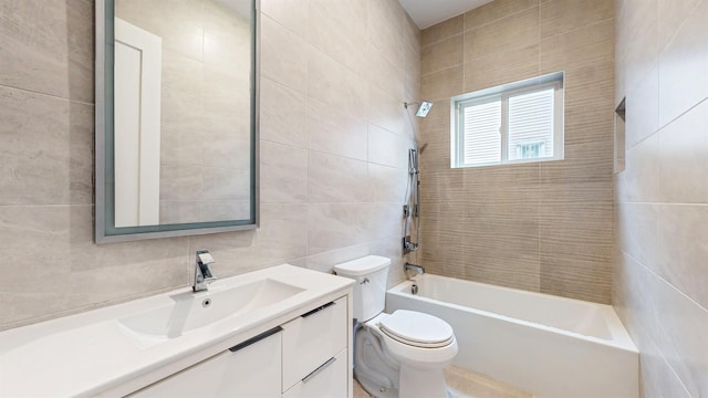bathroom with toilet, vanity,  shower combination, decorative backsplash, and tile walls