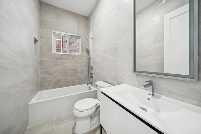 full bath featuring toilet, vanity, shower / bathtub combination, and tile walls