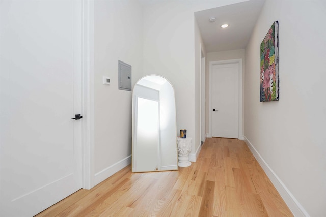 corridor with hardwood / wood-style floors and electric panel