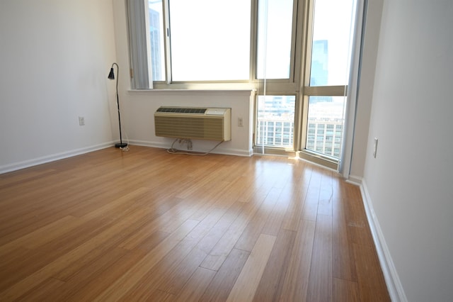 20 2nd St Unit 2111, Jersey City, NJ 07034 - unfurnished living room featuring wood finished floors, a wall unit AC, and baseboards