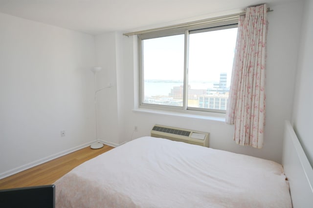 20 2nd St Unit 2111, Jersey City, NJ 07034 - bedroom featuring wood finished floors, multiple windows, a wall mounted AC, and baseboards