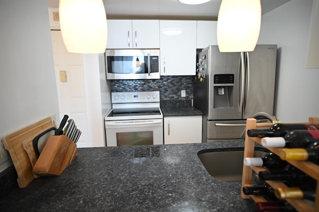20 2nd St Unit 2111, Jersey City, NJ 07034 - kitchen with appliances with stainless steel finishes, white cabinetry, backsplash, and dark stone countertops