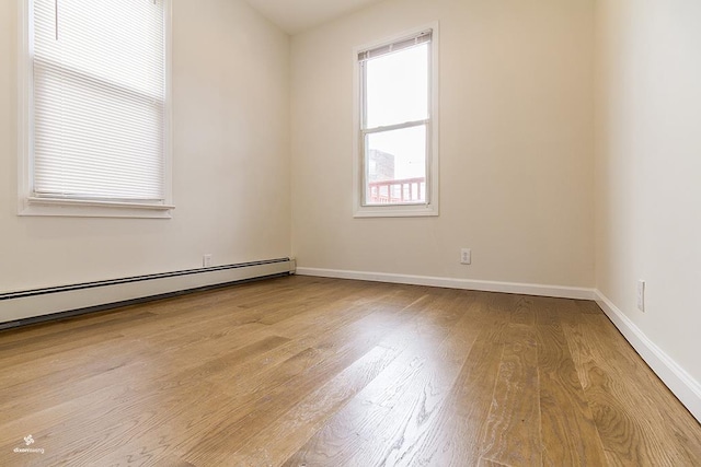 72 W 22nd St, Bayonne, NJ 07002 - empty room with wood finished floors, a baseboard heating unit, and baseboards