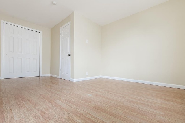72 W 22nd St, Bayonne, NJ 07002 - unfurnished bedroom with light wood-type flooring, baseboards, and a closet