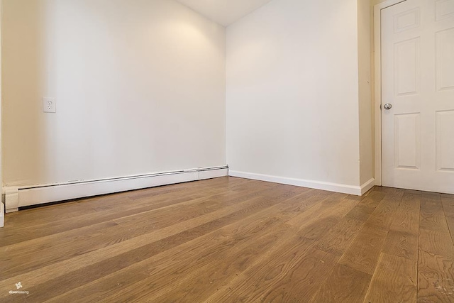 72 W 22nd St, Bayonne, NJ 07002 - empty room featuring wood finished floors, a baseboard heating unit, and baseboards