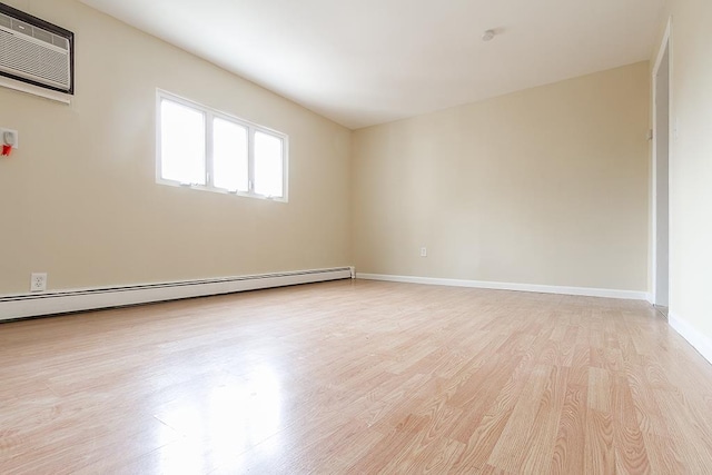 72 W 22nd St, Bayonne, NJ 07002 - empty room featuring light wood-style flooring, a baseboard heating unit, a wall unit AC, and baseboards