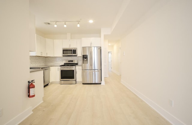107 Laidlaw Ave Unit 2, Jersey City, NJ 07306 - kitchen featuring stainless steel appliances, tasteful backsplash, white cabinetry, and light wood-style floors