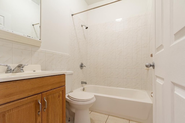 full bathroom with tile walls, vanity, tiled shower / bath, tile patterned flooring, and toilet