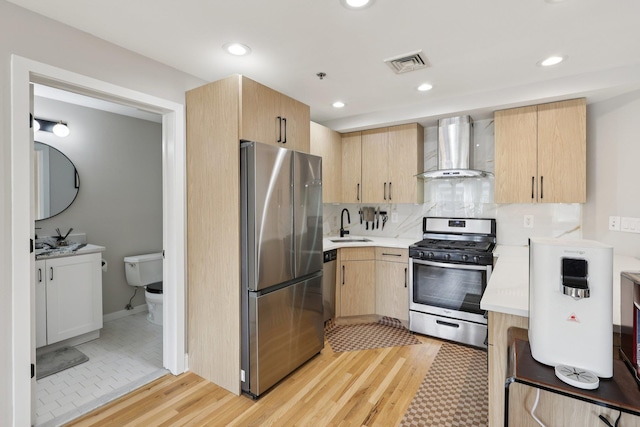609 Jefferson St Unit 4D, Hoboken, NJ 07030 - kitchen featuring wall chimney exhaust hood, appliances with stainless steel finishes, light brown cabinets, light wood-type flooring, and light countertops