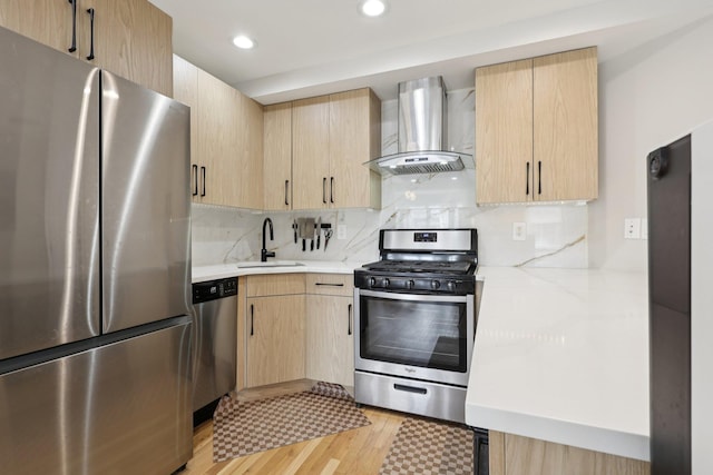 609 Jefferson St Unit 4D, Hoboken, NJ 07030 - kitchen featuring stainless steel appliances, wall chimney range hood, light brown cabinets, decorative backsplash, and light wood-style flooring