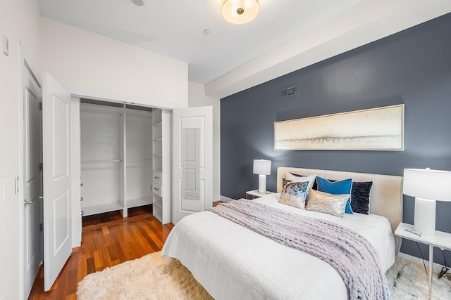 bedroom featuring a closet, wood finished floors, and baseboards