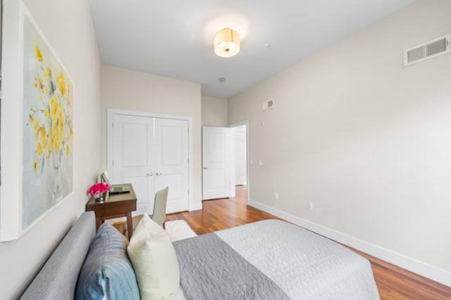 bedroom featuring wood finished floors, baseboards, and a closet