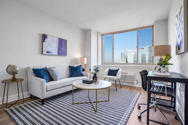 1 2nd St Unit 1012, Jersey City, NJ 07302 - living room with an office area, wood finished floors, and a wall unit AC