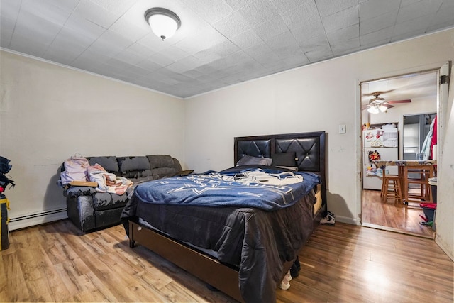 bedroom featuring a baseboard radiator and wood finished floors