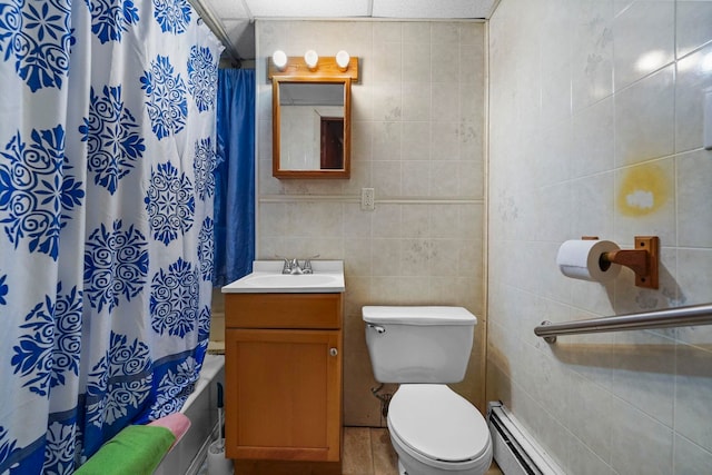 full bath with tile walls, toilet, shower / bath combo with shower curtain, a baseboard heating unit, and vanity